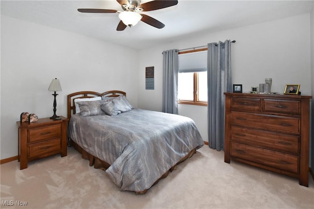 bedroom with light carpet, baseboards, and a ceiling fan