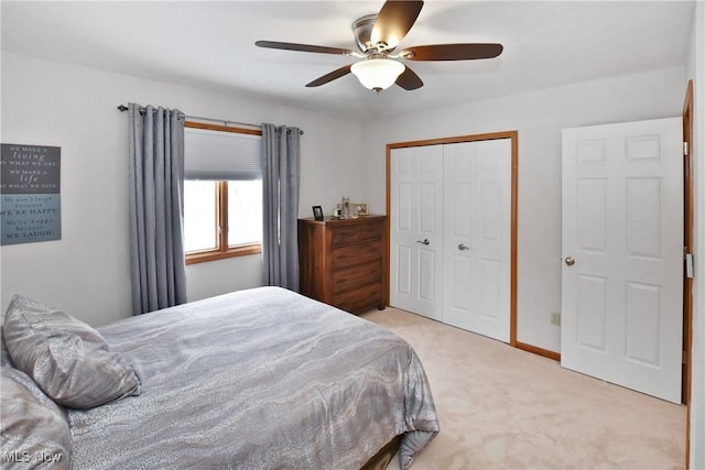 bedroom featuring a closet, light colored carpet, ceiling fan, and baseboards