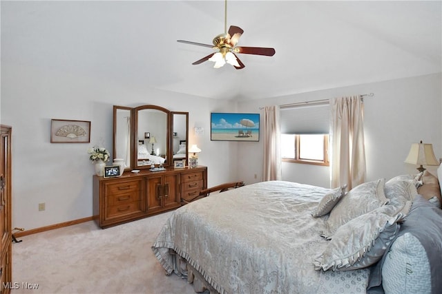 bedroom featuring a ceiling fan, light carpet, vaulted ceiling, and baseboards