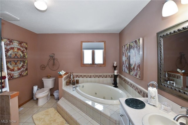 full bathroom featuring toilet, vanity, a whirlpool tub, baseboards, and tile patterned floors