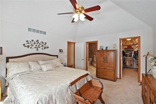 bedroom featuring lofted ceiling, light carpet, visible vents, a closet, and a walk in closet