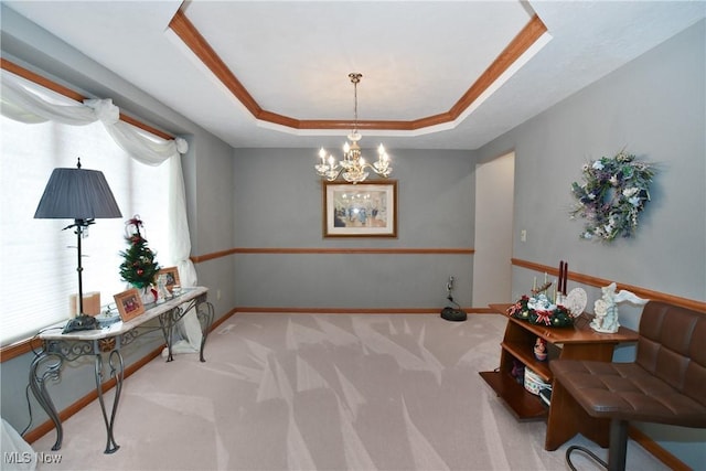 sitting room with a notable chandelier, a raised ceiling, ornamental molding, and light carpet