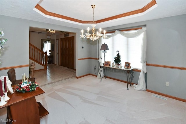 interior space featuring stairway, a raised ceiling, visible vents, and a notable chandelier