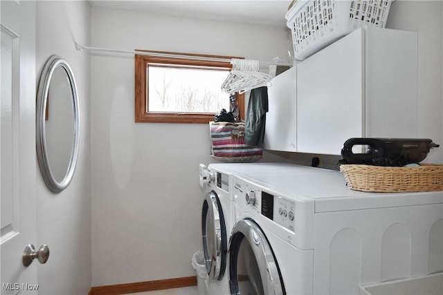 laundry room with washing machine and dryer, cabinet space, and baseboards