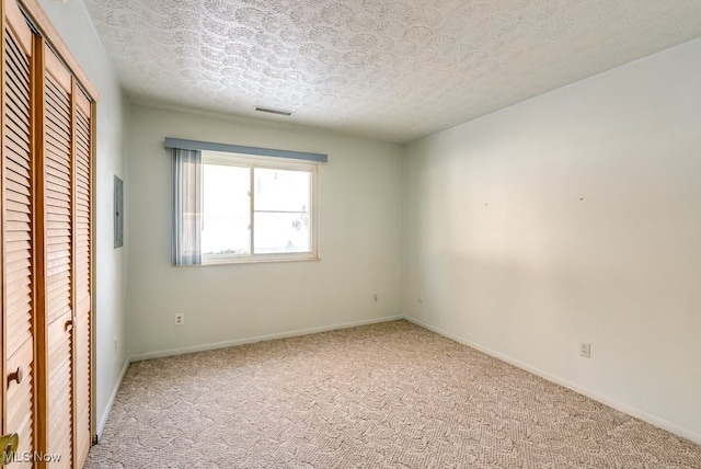 carpeted spare room featuring a textured ceiling