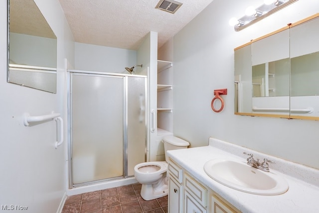 bathroom featuring a textured ceiling, toilet, a shower with door, and vanity