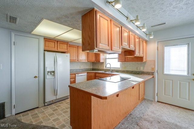 kitchen featuring a kitchen breakfast bar, kitchen peninsula, sink, and white appliances