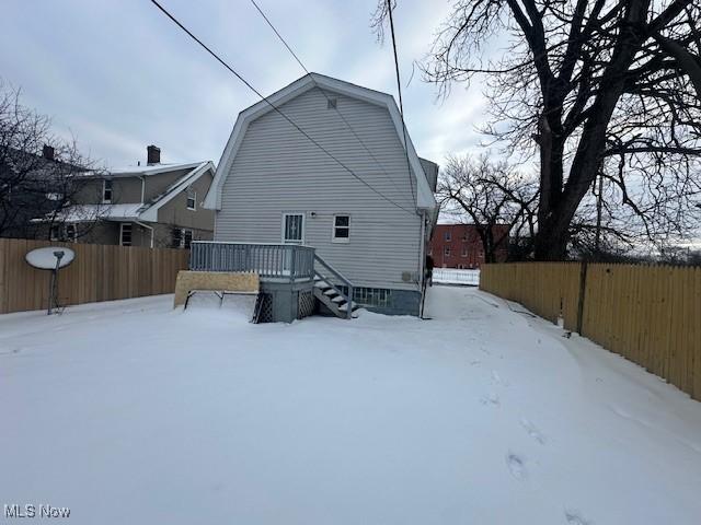 snow covered property featuring a wooden deck