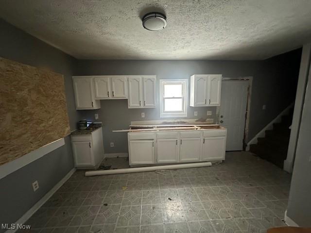 kitchen featuring white cabinetry and a textured ceiling