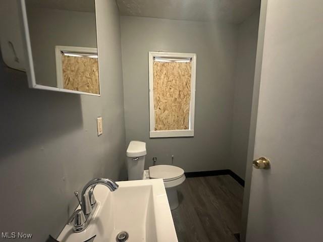 bathroom featuring sink, hardwood / wood-style floors, and toilet