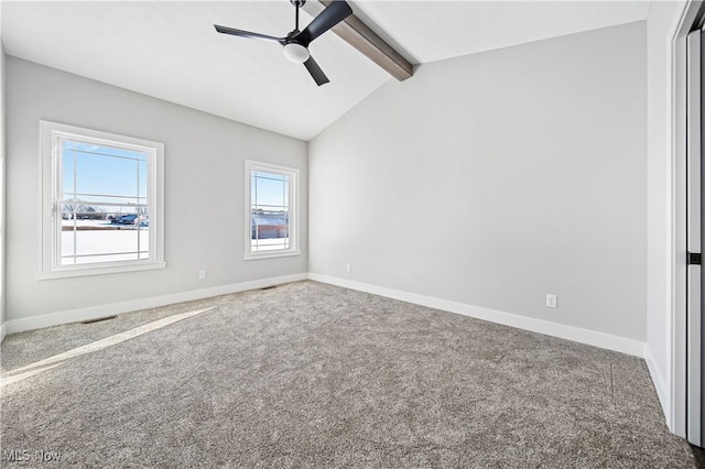 carpeted empty room featuring ceiling fan, lofted ceiling with beams, and plenty of natural light