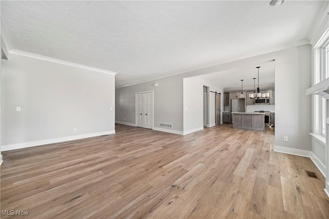 unfurnished living room with an inviting chandelier, ornamental molding, and light hardwood / wood-style floors