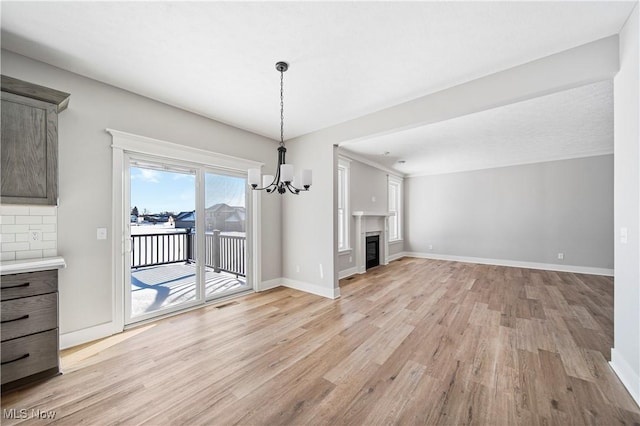 unfurnished living room with light hardwood / wood-style flooring and an inviting chandelier