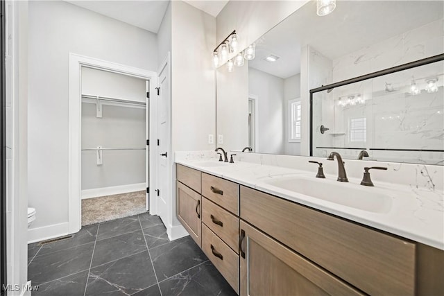 bathroom featuring toilet, vanity, and a shower with door