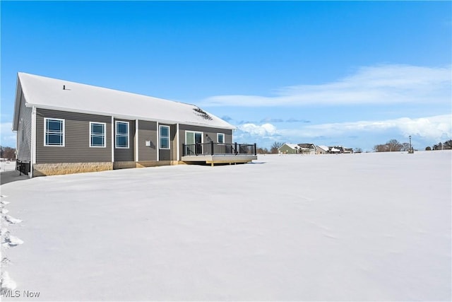 snow covered house with a wooden deck