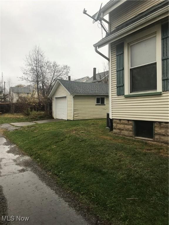 view of property exterior featuring a garage, an outbuilding, and a yard