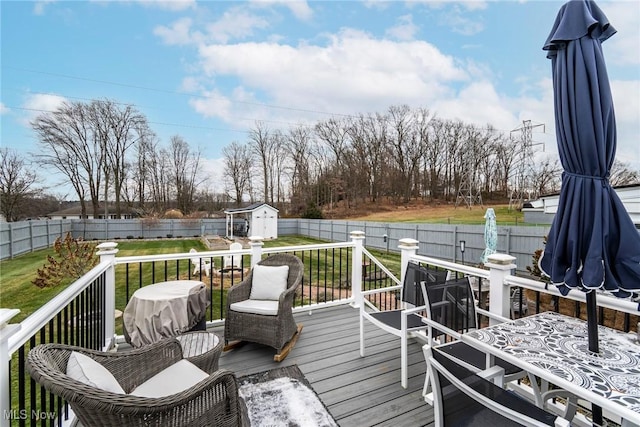 deck featuring a yard and a storage unit