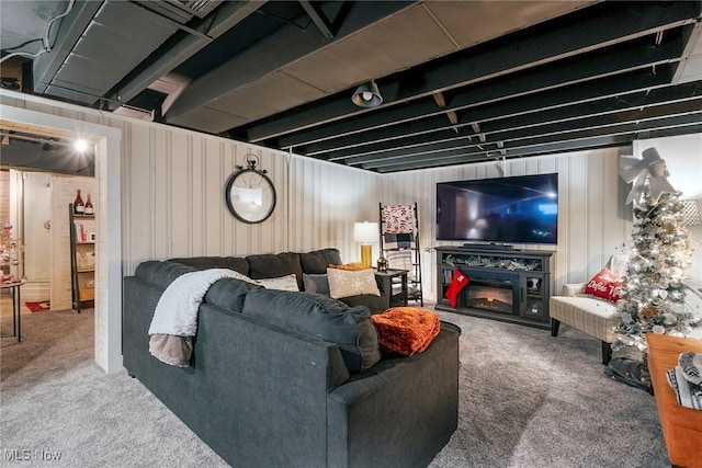 carpeted living room with wood walls and a fireplace