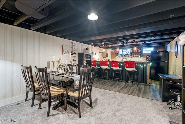 carpeted dining room featuring bar area