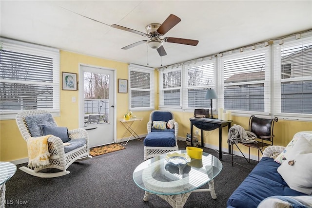 living room featuring ceiling fan, plenty of natural light, and dark carpet