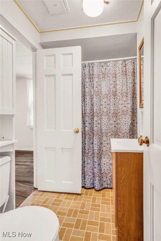 bathroom with curtained shower, toilet, and vanity