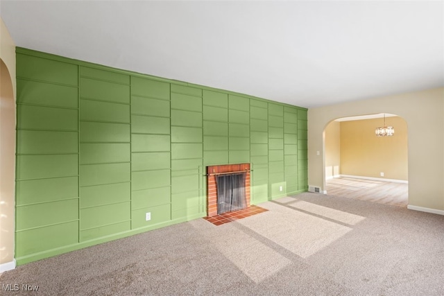 unfurnished living room featuring carpet and a brick fireplace