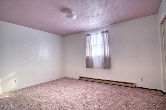 carpeted empty room featuring baseboard heating