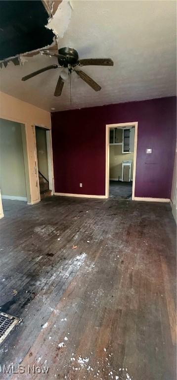 unfurnished living room with dark wood-type flooring and ceiling fan