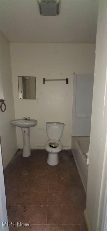 bathroom with sink, a bathing tub, and toilet