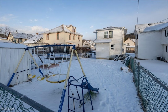 yard covered in snow with a trampoline