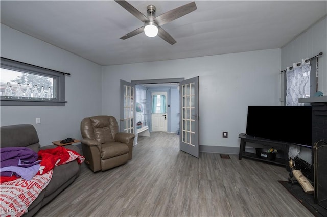 living room featuring hardwood / wood-style flooring, ceiling fan, and french doors