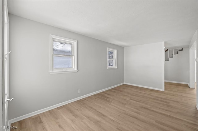 empty room with light hardwood / wood-style floors and a wealth of natural light