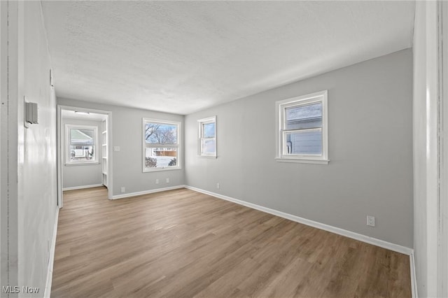 spare room with light hardwood / wood-style flooring and a textured ceiling