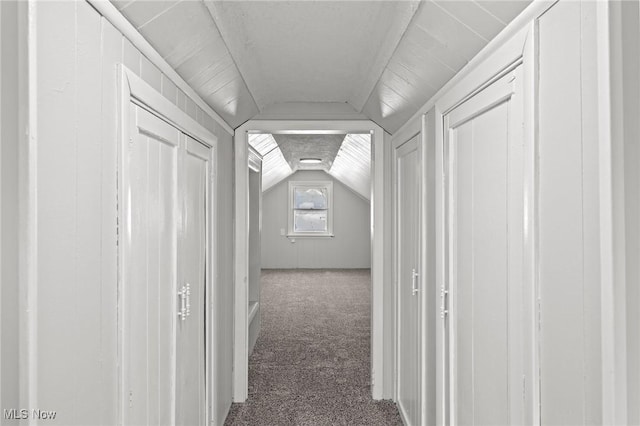 hall with carpet flooring and vaulted ceiling