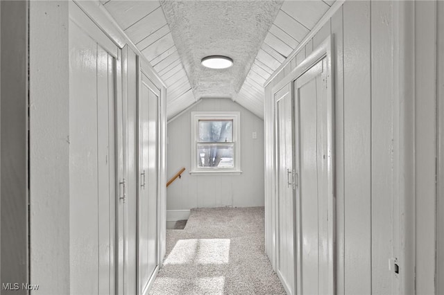 hallway with light carpet and lofted ceiling