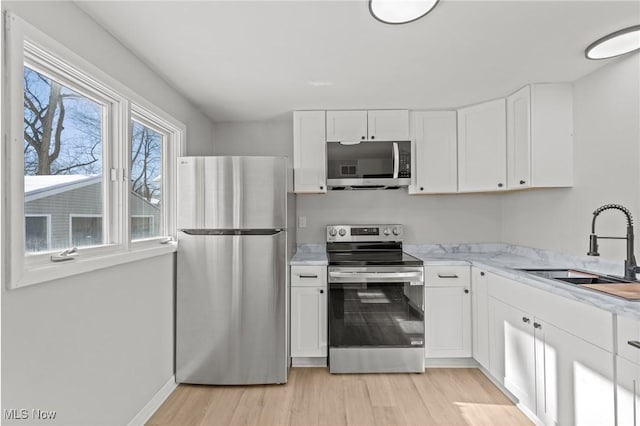 kitchen featuring sink, light hardwood / wood-style flooring, white cabinets, and appliances with stainless steel finishes