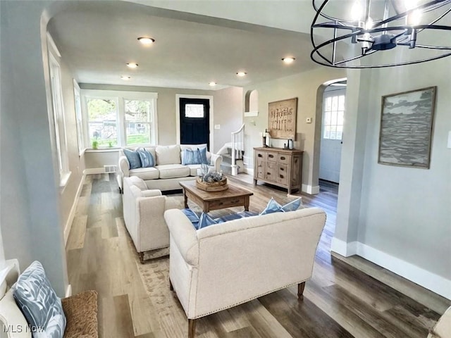 living room with wood-type flooring and a notable chandelier