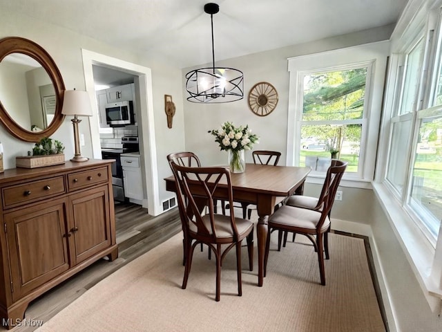 dining area with dark wood-type flooring and a chandelier