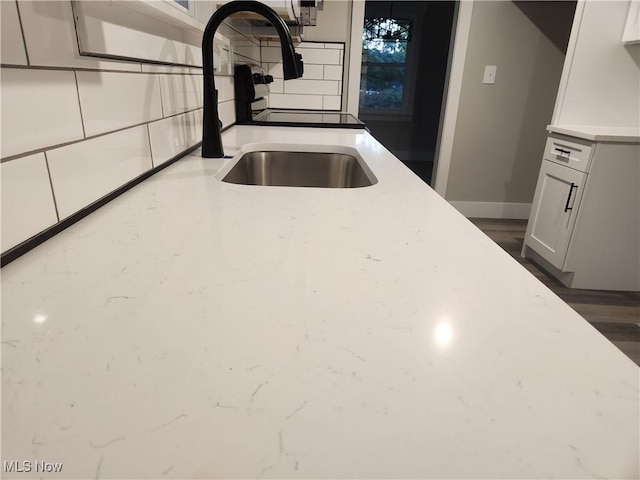 kitchen featuring decorative backsplash, sink, white cabinets, and dark hardwood / wood-style floors