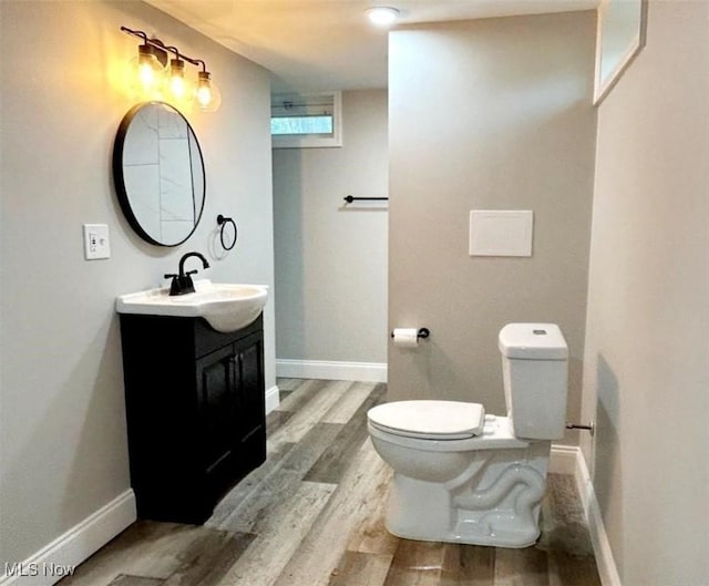 bathroom featuring vanity, toilet, and hardwood / wood-style flooring