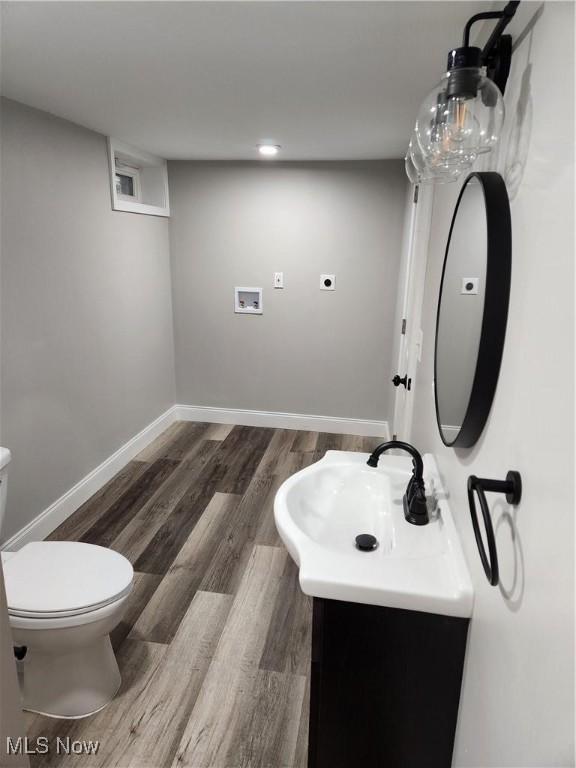 bathroom with vanity, toilet, and wood-type flooring