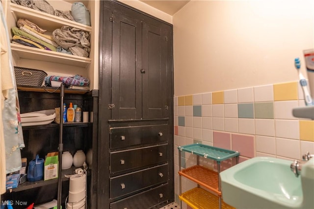 bathroom featuring sink and tile walls