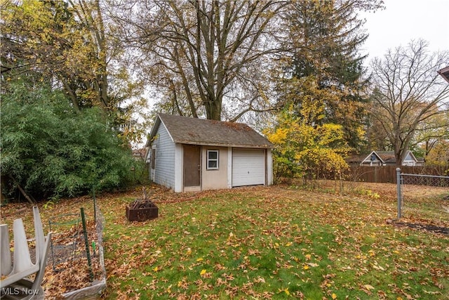 view of yard with a garage and an outbuilding