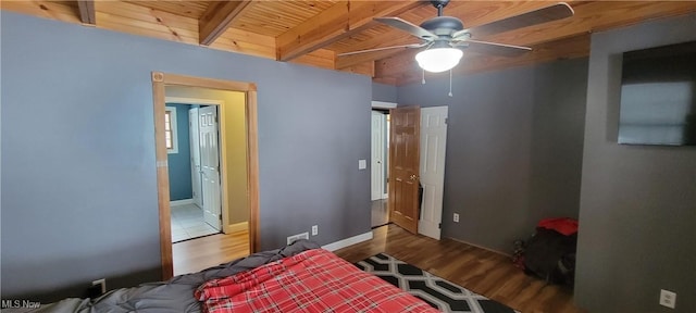 bedroom featuring beamed ceiling, wood finished floors, wood ceiling, and baseboards