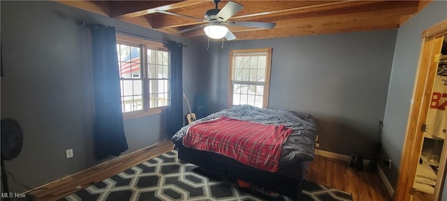 bedroom with ceiling fan, baseboards, and wood finished floors