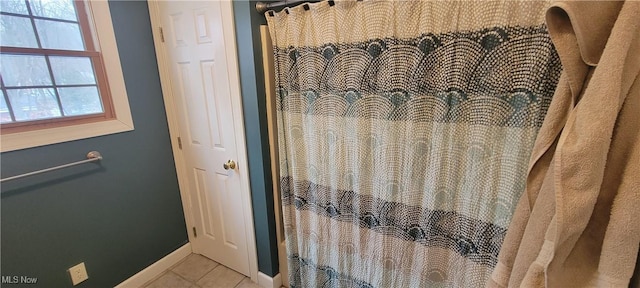 full bath featuring curtained shower, baseboards, and tile patterned floors