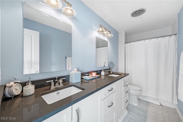 bathroom with curtained shower, toilet, and vanity