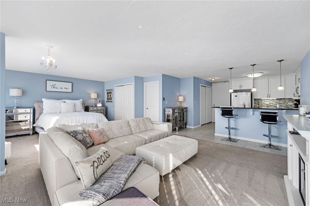 carpeted bedroom featuring white fridge and an inviting chandelier