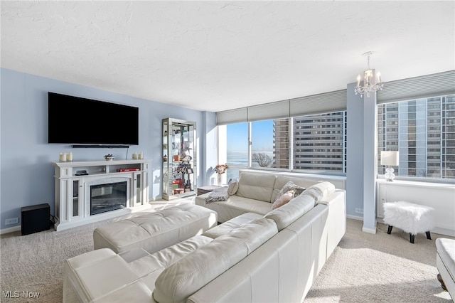 living room with light colored carpet, a premium fireplace, and an inviting chandelier