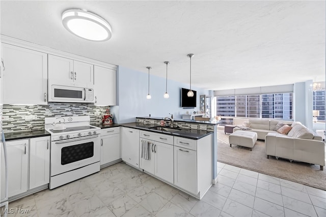 kitchen featuring white appliances, white cabinets, sink, backsplash, and hanging light fixtures